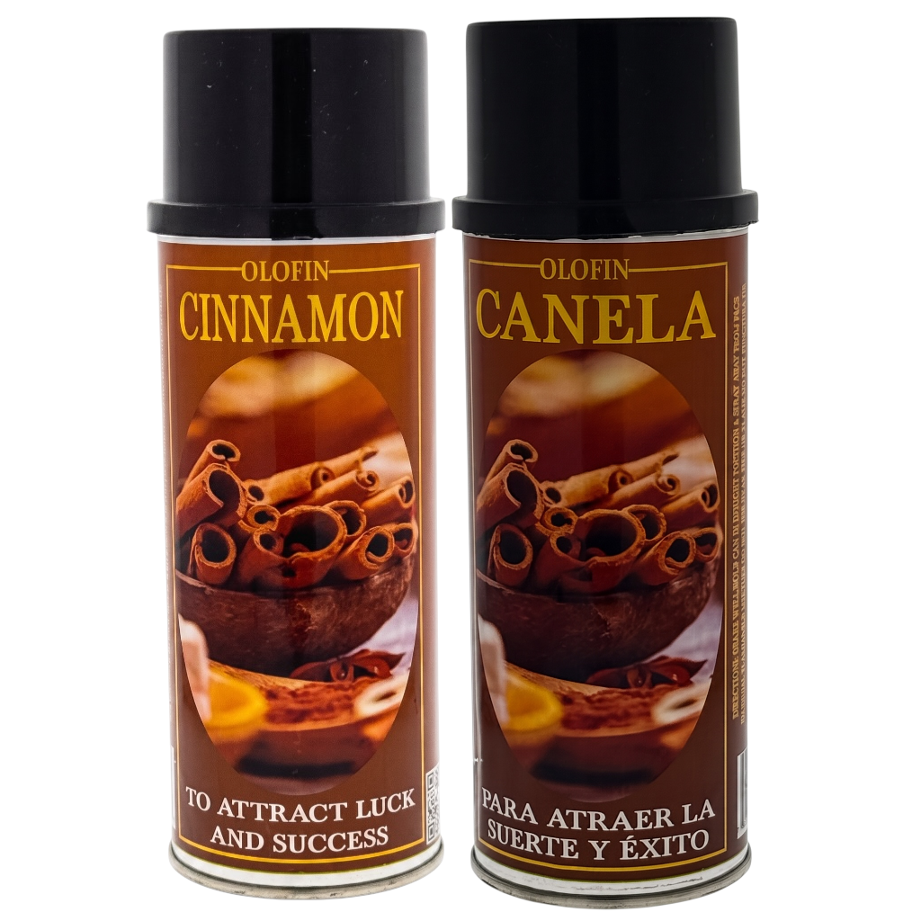 Two Olofin spray cans labeled Cinnamon and Canela, featuring brown labels with cinnamon illustrations and black caps, set against a plain white background.