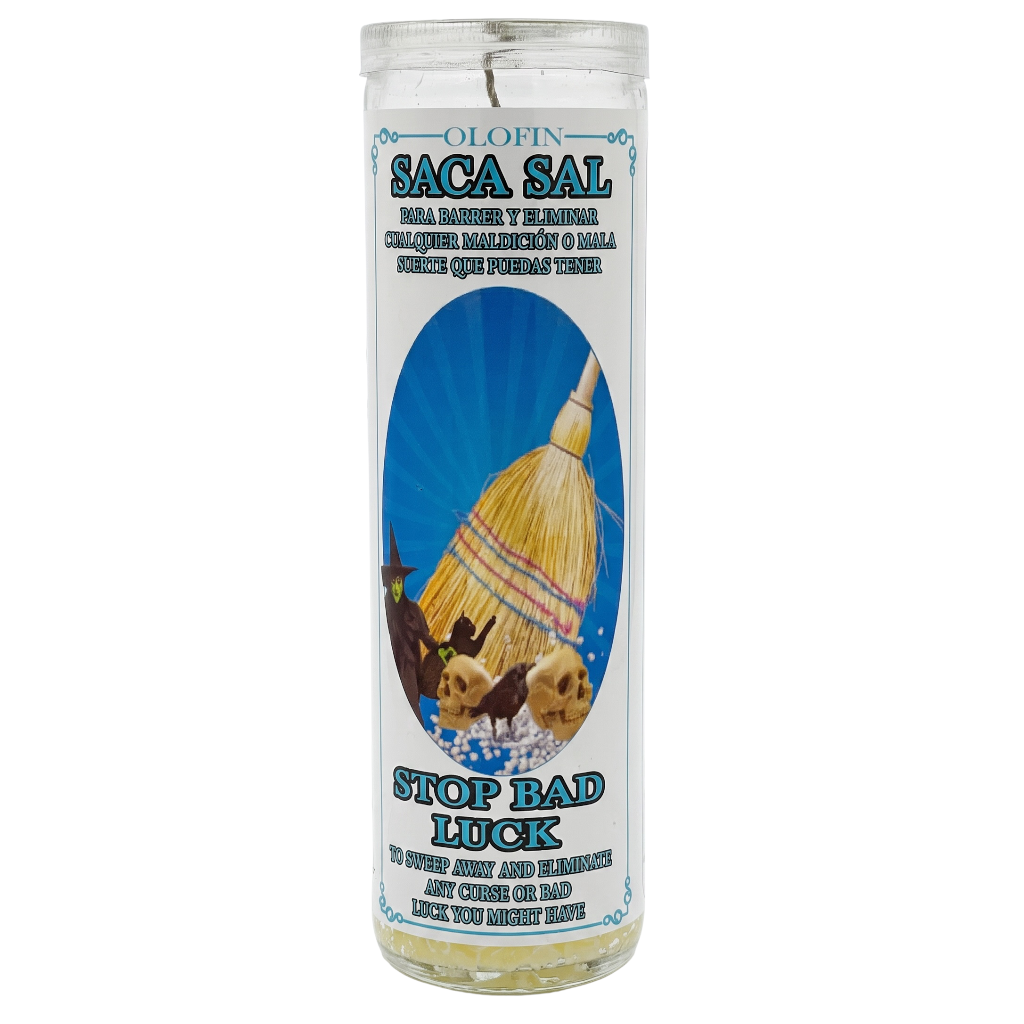 A tall clear glass prayer candle with a white label featuring the brand 'Olofin' and product name 'Saca Sal'. The label has a blue sunburst background with an illustration of a yellow and red thatched hut, alongside the text 'Stop Bad Luck'.