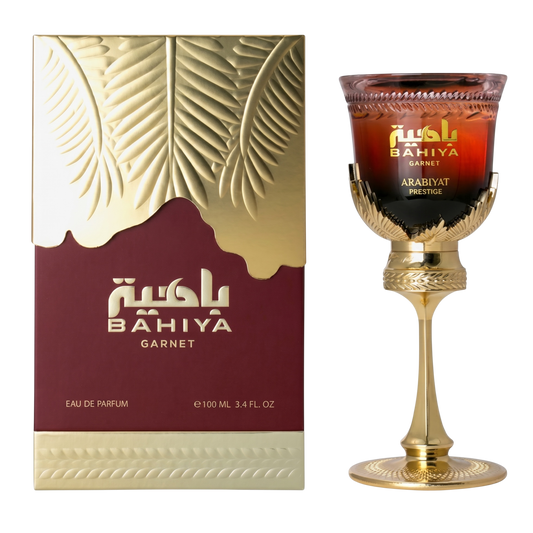Bahiya Garnet perfume packaging and a decorative glass with gold accents.