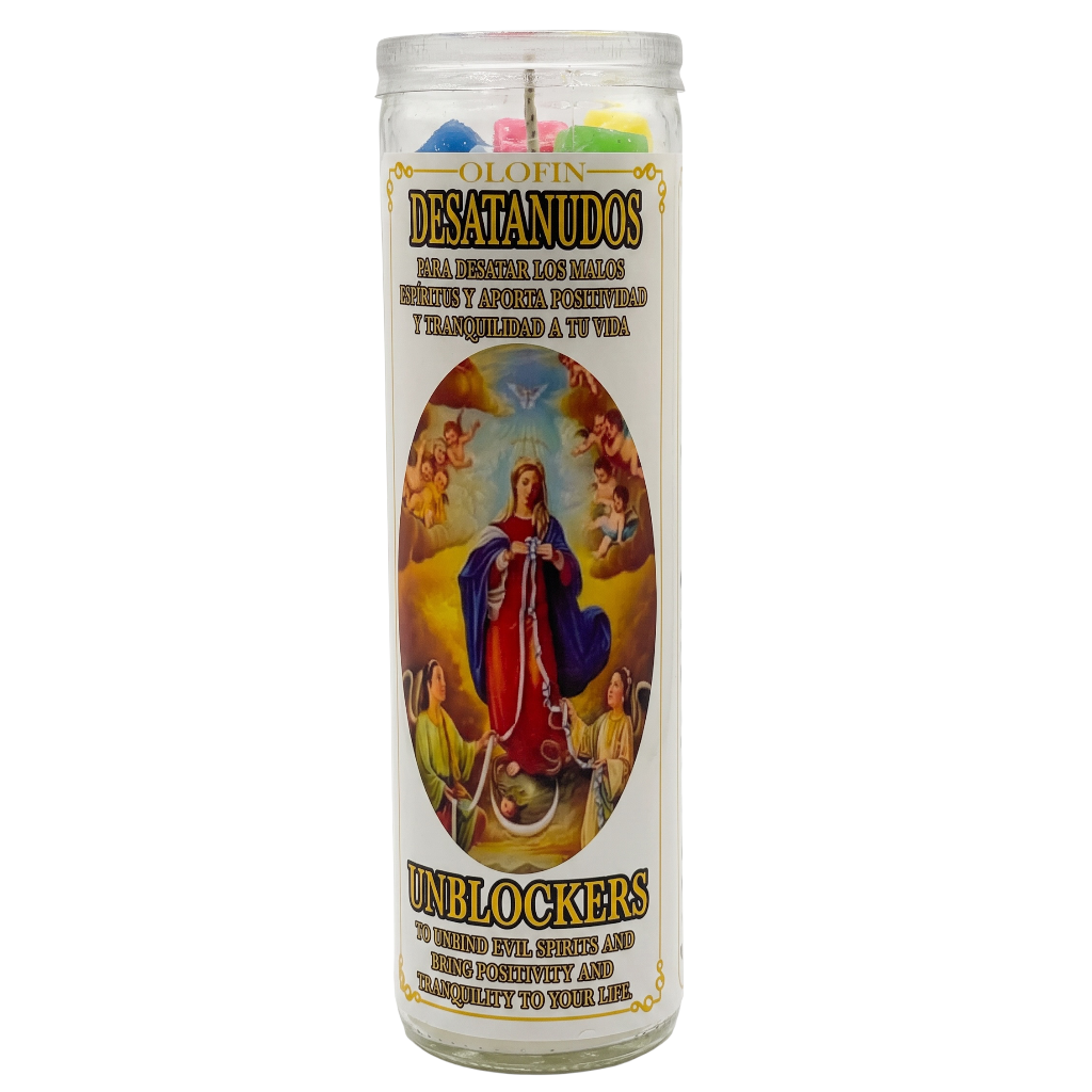 A tall glass prayer candle with a white label featuring a religious illustration of the Virgin Mary and Spanish text reading 'OLIVIN DESATANUDOS' and 'UNBLOCKERS'. Colorful wax pieces are visible at the top inside the clear glass container.