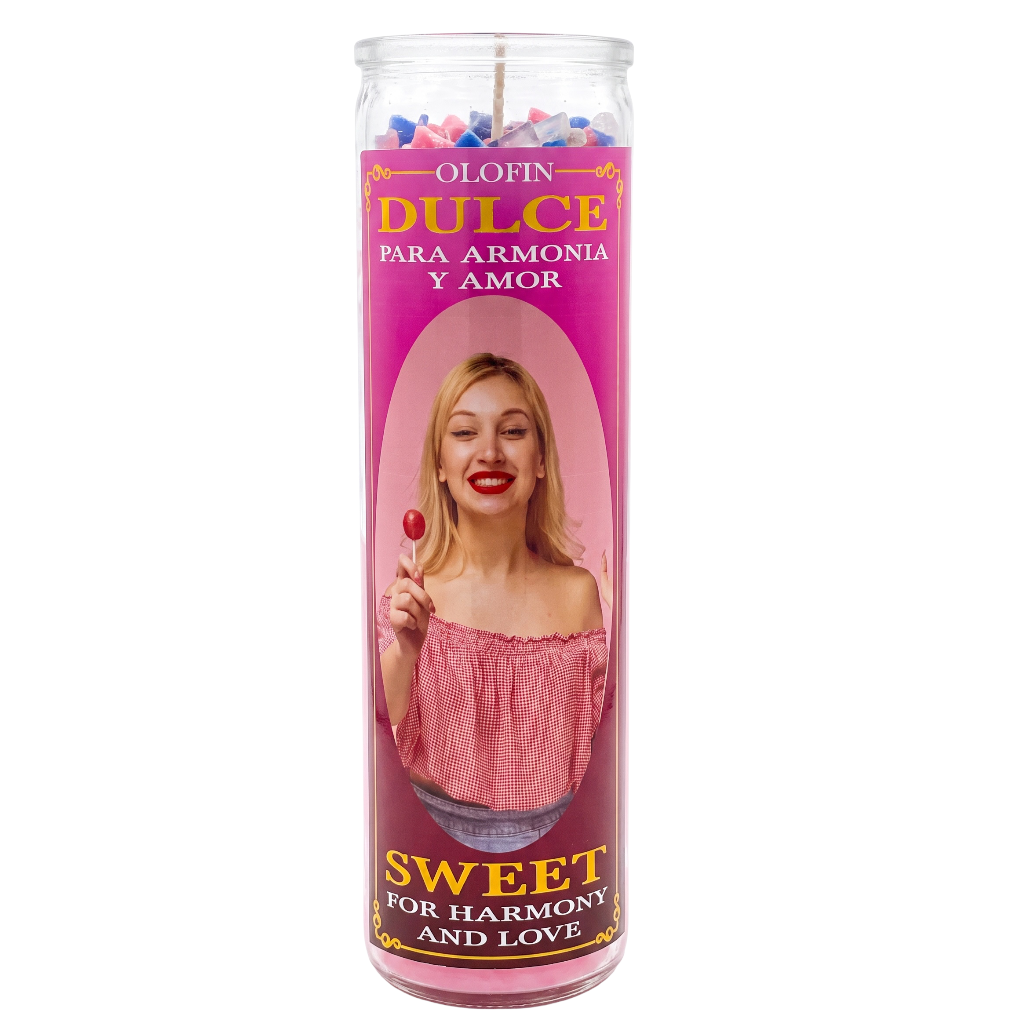 A tall glass jar candle with a pink label reading 'Olofin Dulce' and 'Sweet for Harmony and Love,' featuring a photo of a woman holding a lollipop on the front.