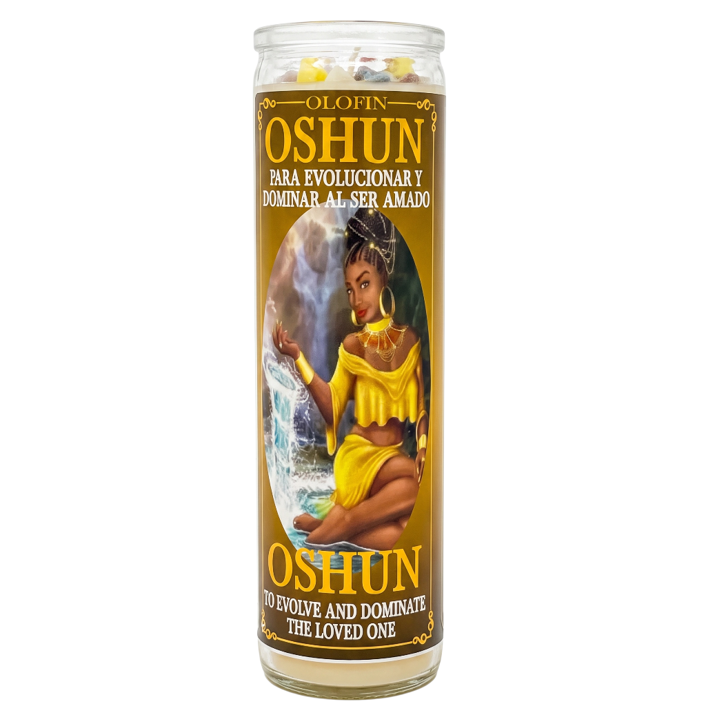 A tall glass jar candle with a brown and gold label featuring an illustration of Oshun and Spanish text, shown on a plain white background.