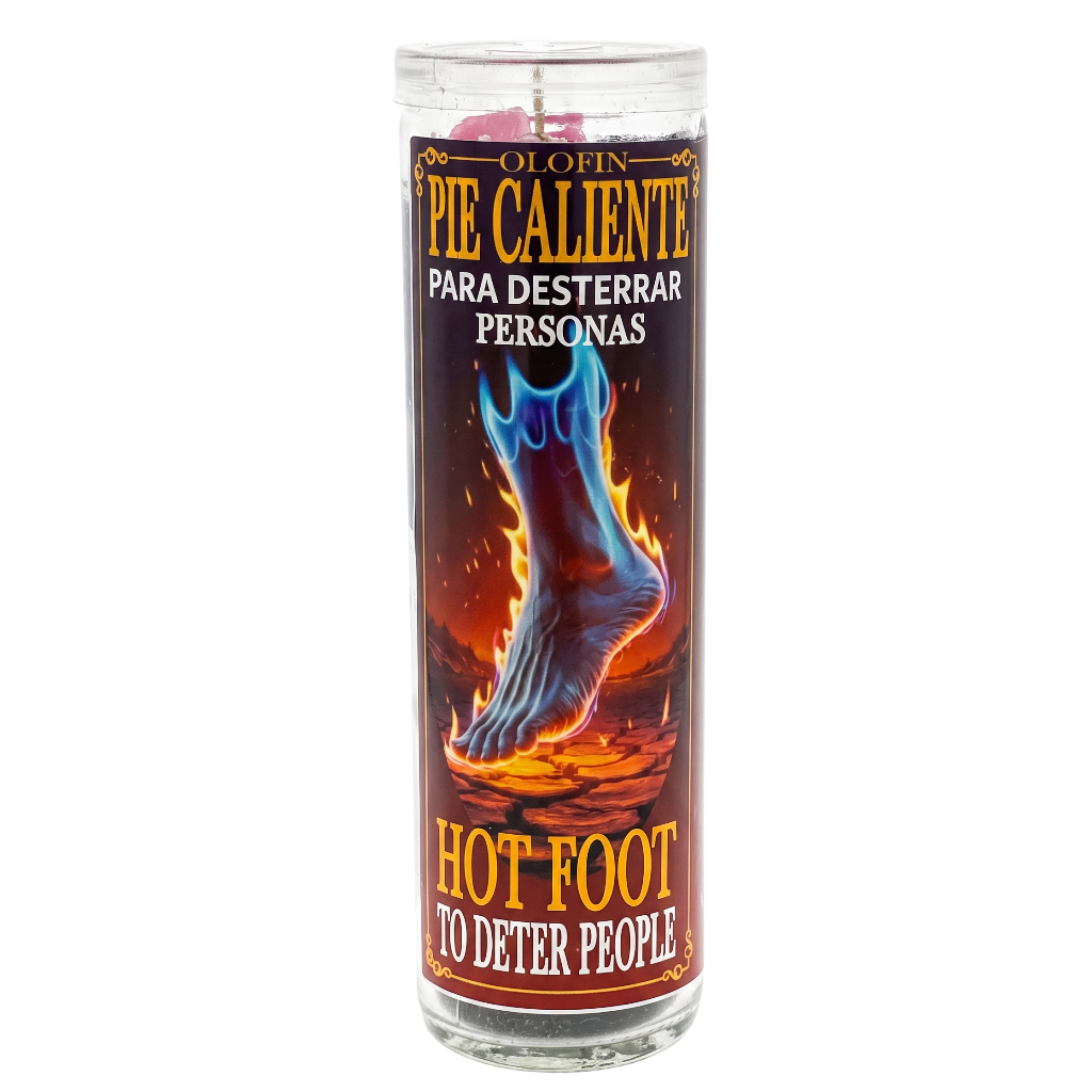 A tall glass jar candle with a printed label reading 'O INPIE PIE CALIENTE PARA DESTERRAR PERSONAS / HOT FOOT TO DETER PEOPLE,' showing a blue foot engulfed in flames on a dark background.
