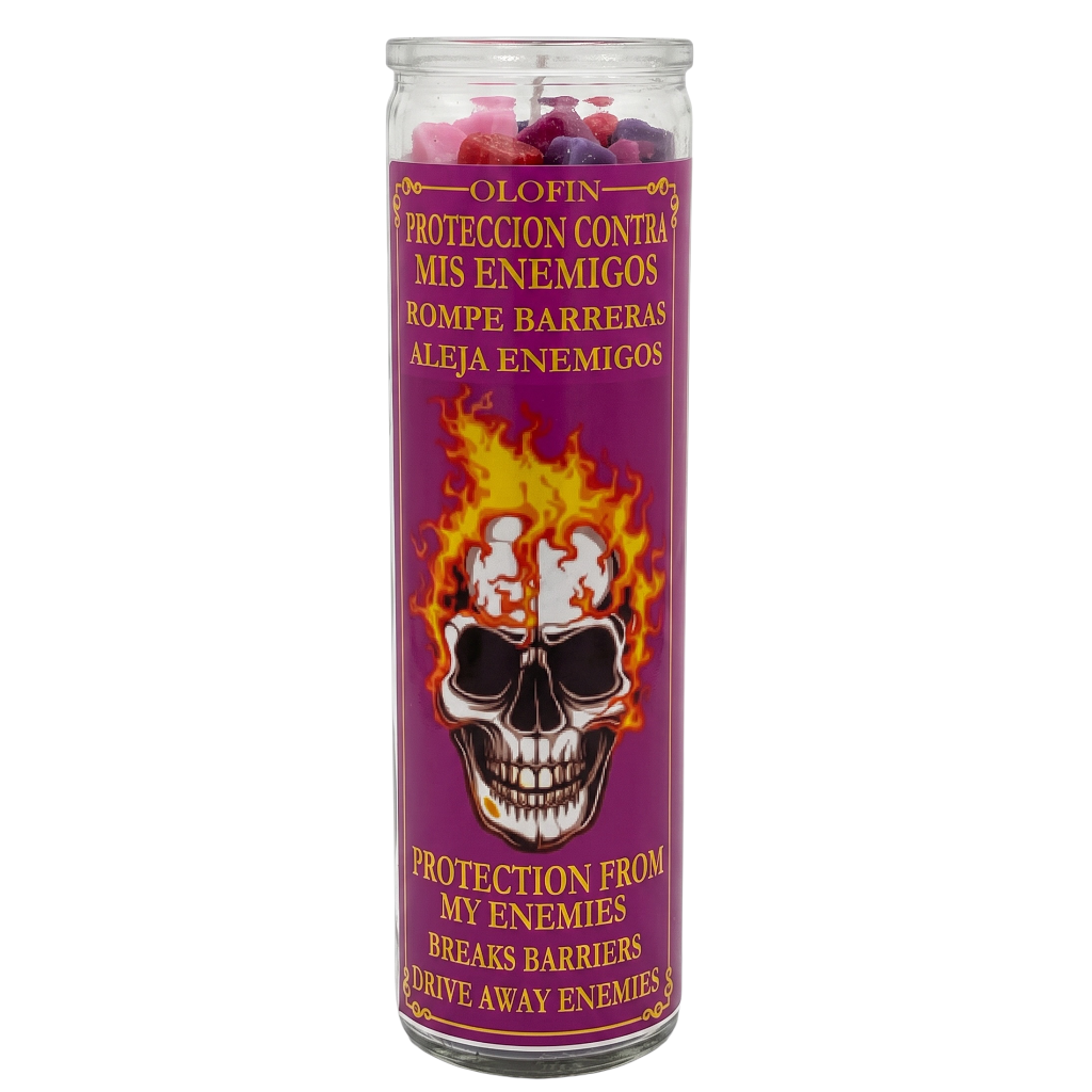 A tall glass jar candle with a purple label featuring a skull and flames, labeled in Spanish and English as protection from enemies.