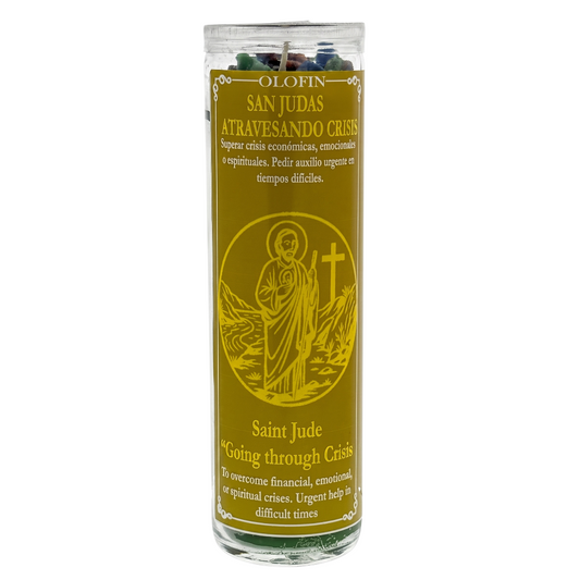 A Saint Jude Catholic prayer candle in a tall clear glass jar with a gold-colored label featuring an illustration of Saint Jude and the text 'OLIN SAN JUDAS ATRAVESANDO CRISIS' and 'Saint Jude Going through Crisis'.