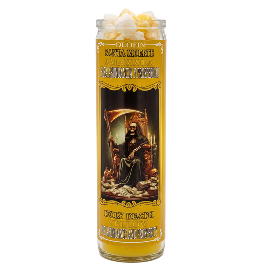 A tall glass jar candle with a yellow and black label featuring Santa Muerte artwork, topped with white popcorn pieces, on a plain white background.