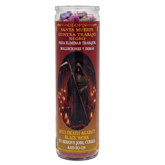 A tall glass jar candle with a red and black label featuring a grim reaper illustration. The top of the candle is filled with purple and pink wax pieces.