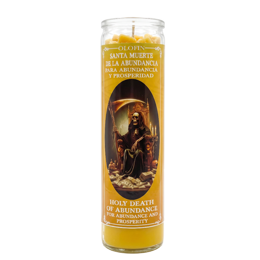 A tall glass jar candle with a yellow wax body and a printed label featuring Santa Muerte. The label includes Spanish text ('Santa Muerte de la abundancia para abundancia y prosperidad') and English text ('Holy Death of Abundance for Abundance and Prosperity').