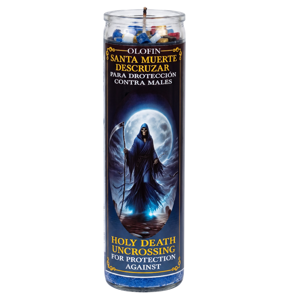 A tall glass prayer candle with a dark blue label featuring Santa Muerte under a full moon. The label reads 'Olofin Santa Muerte Descuzar' and 'Holy Death Uncrossing for Protection Against Males,' with multicolored wax pieces visible at the top.