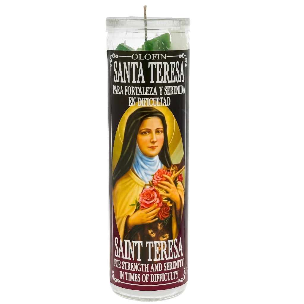 A tall glass jar candle with a printed devotional label featuring Saint Teresa, shown on a plain white background. The candle wax at the top appears green, and the label text includes 'Santa Teresa' and 'Saint Teresa' with Spanish and English wording about strength and serenity in times of difficulty.