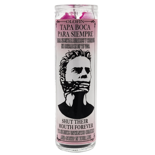 A tall glass jar candle with a white label featuring a black illustrated portrait of a gagged face and Spanish text reading 'Olofin Tapa Boca Para Siempre' and 'Shut Their Mouth Forever.' The candle wax at the top is pink, and the label border is light pink.