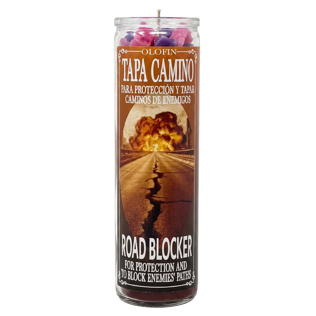 A tall glass jar candle labeled 'Olofin Tapa Camino Road Blocker' with a printed label showing a road leading to an explosion. The candle is shown upright on a plain white background.