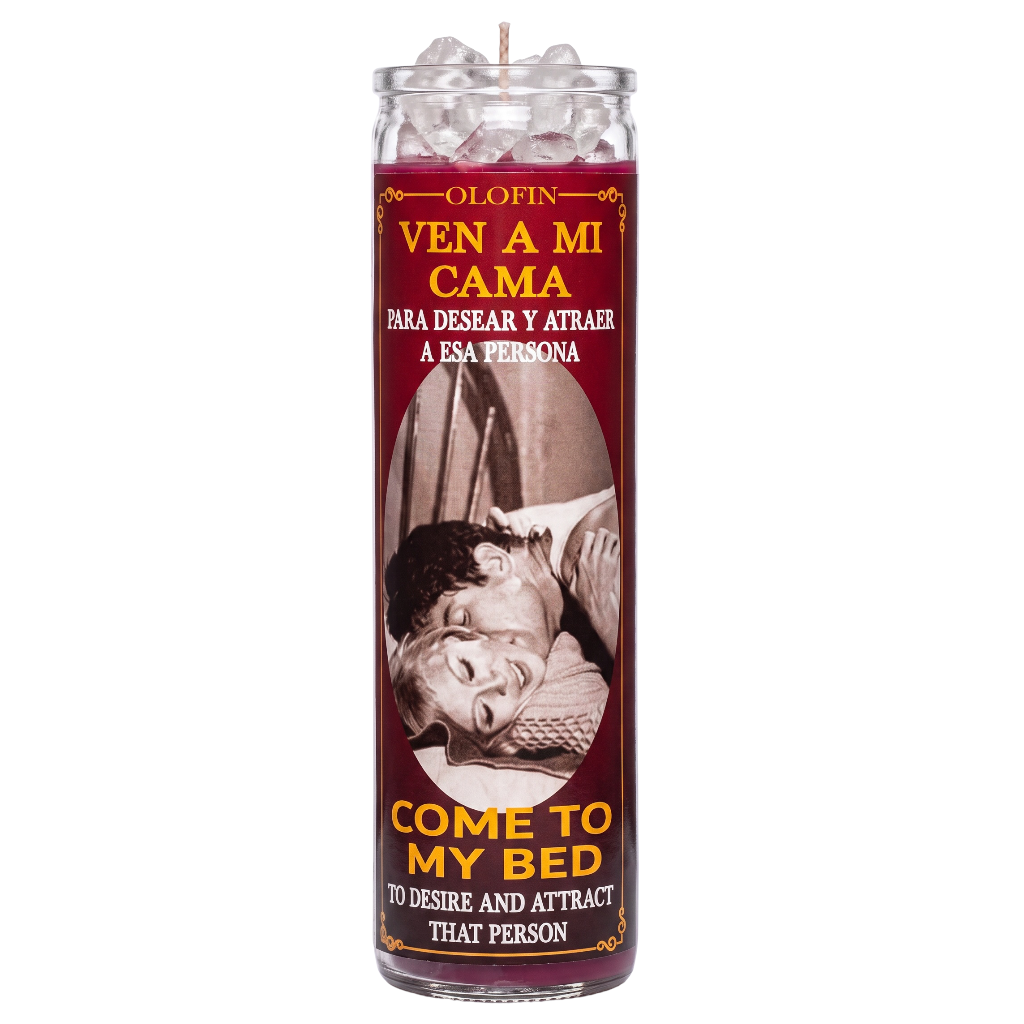 A tall glass jar candle with a maroon label reading 'Olofin Ven a mi cama' and 'Come to my bed' in yellow text, featuring a vintage-style couple photo on the front. The candle is shown upright on a plain white background.