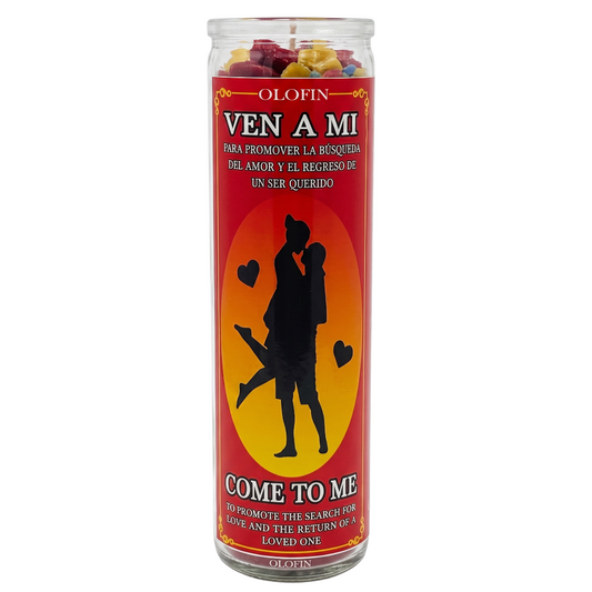 A tall glass jar candle with a red and orange label reading 'OLEFIN VEN A MI' and 'COME TO ME,' featuring a black silhouette of a couple on a yellow-orange circle, with rose petals visible at the top.
