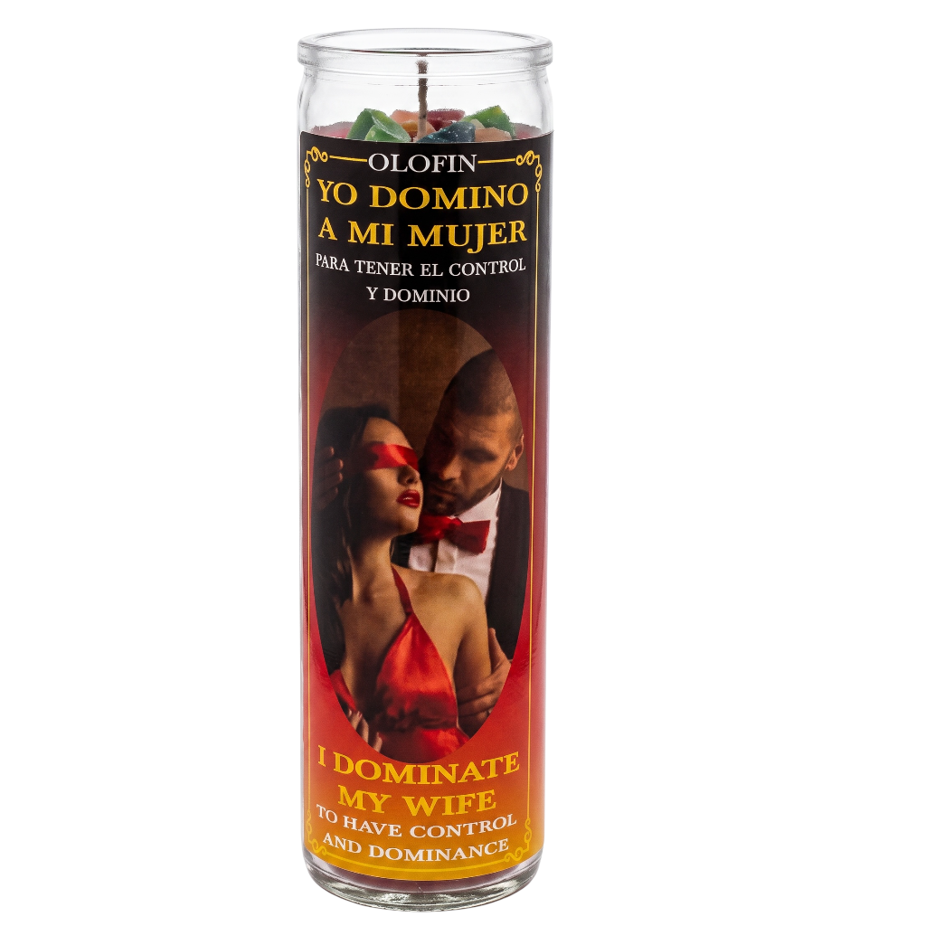 A tall glass jar candle with a Spanish and English label reading 'Yo Domino a mi Mujer' and 'I Dominate My Wife,' featuring a red-toned photo of a couple and yellow text on a white background.